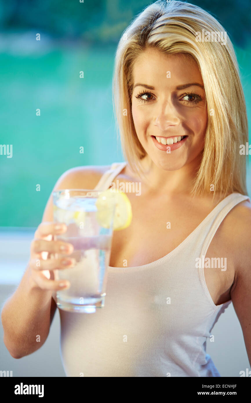 Fille de boire dans un verre d'eau glacée au citron Banque D'Images