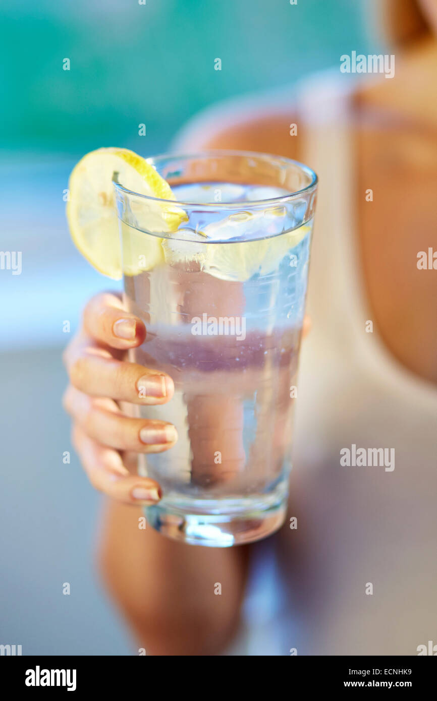 Fille de boire dans un verre d'eau glacée au citron Banque D'Images