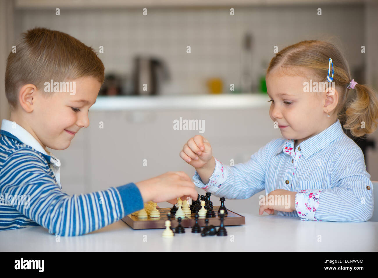 Mignon deux enfants jouant aux échecs à la maison Banque D'Images