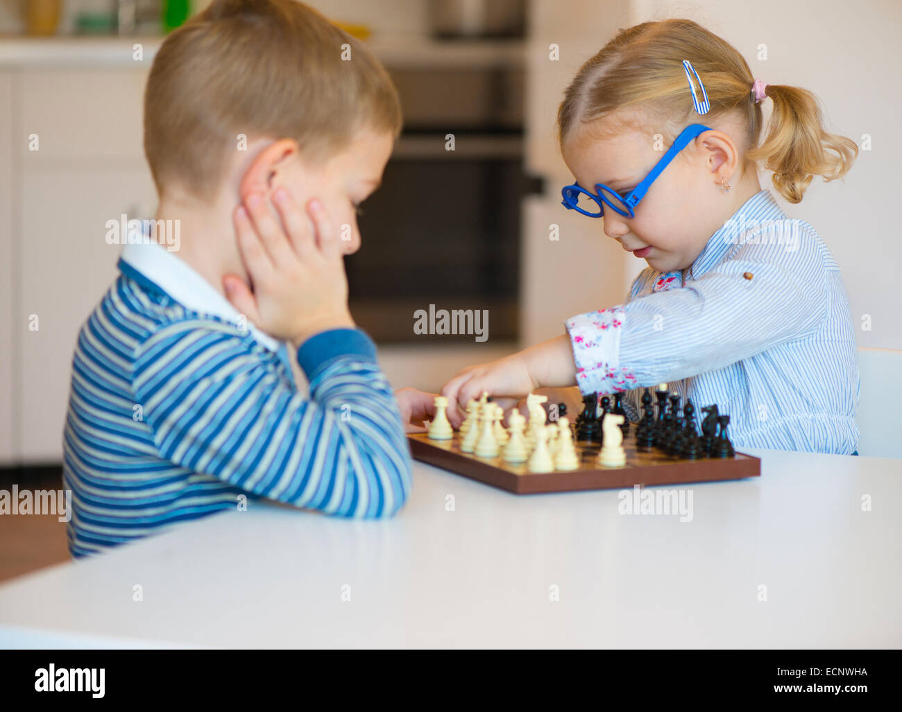 Mignon deux enfants jouant aux échecs à la maison Banque D'Images