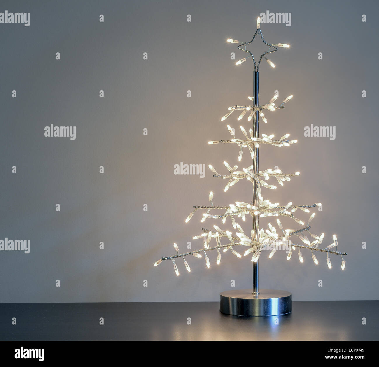 Minimaliste en métal argenté avec ornement d'arbre de Noël feux blanc contre un fond neutre avec copyspace Banque D'Images