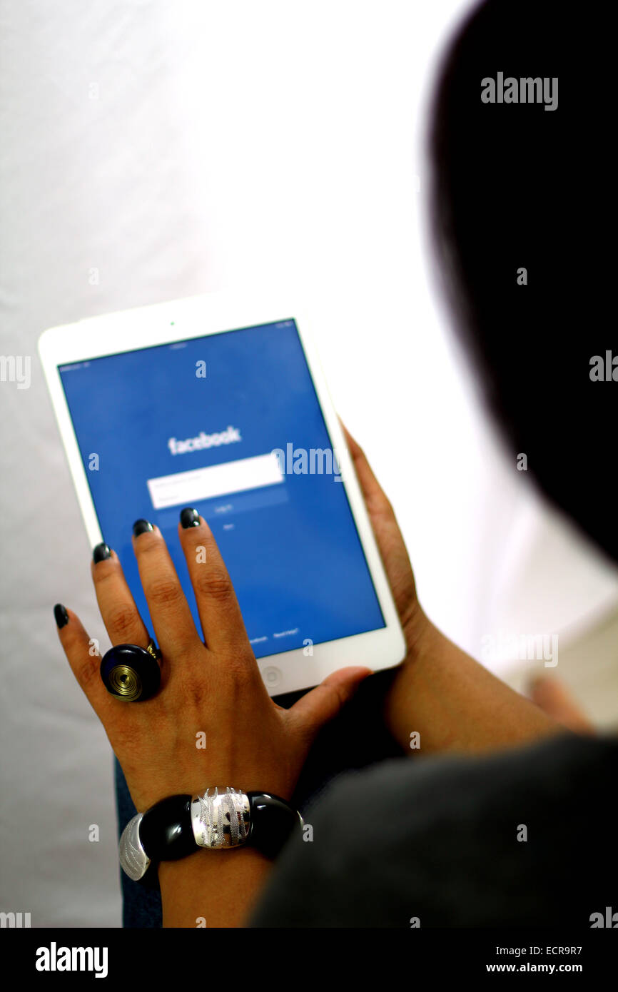 Femme de l'utilisation de facebook dans un iPad Banque D'Images