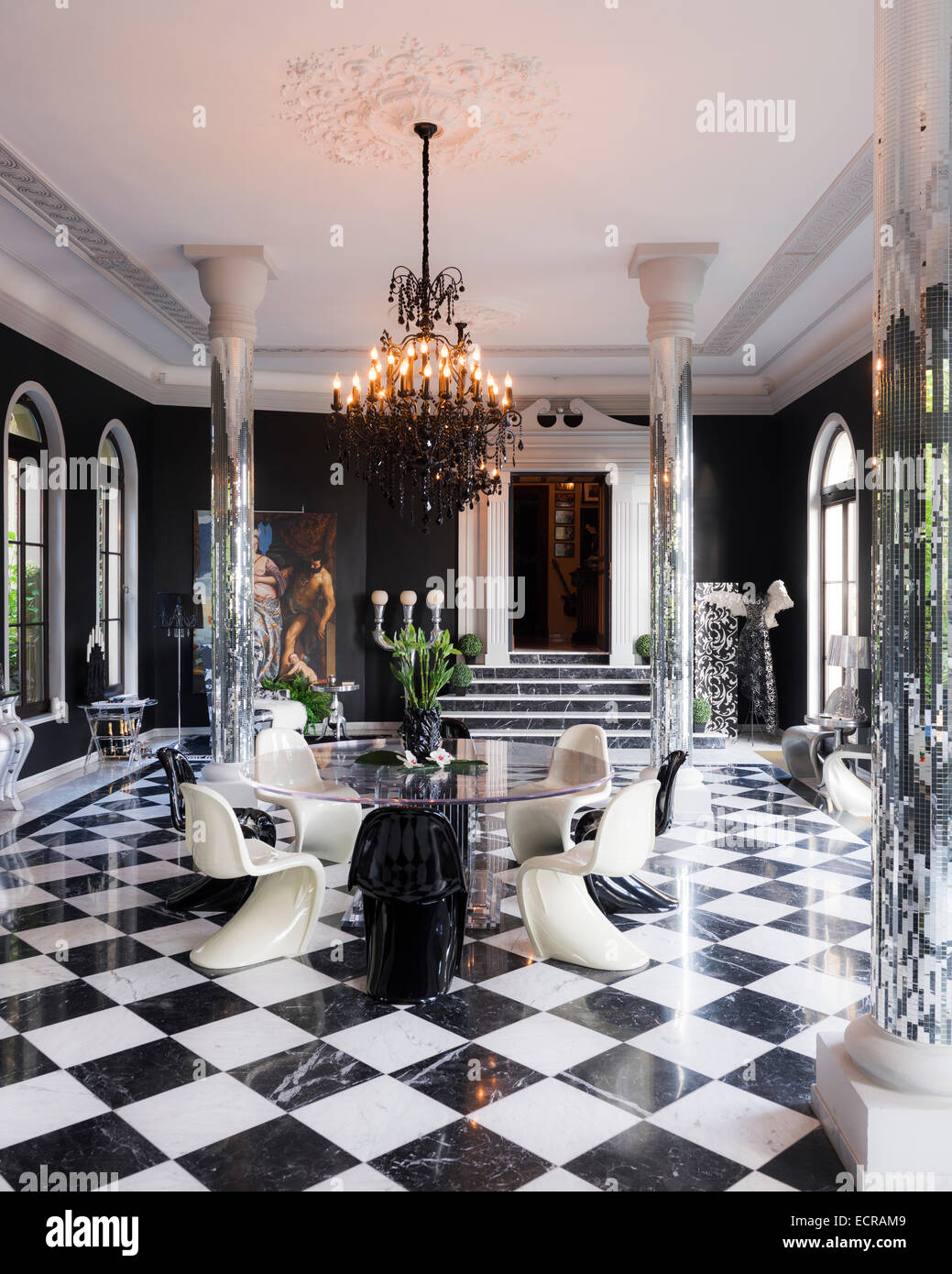 Piliers en miroir dans la chambre de style orangerie avec Panton S chaises et de carrelage noir et blanc Banque D'Images
