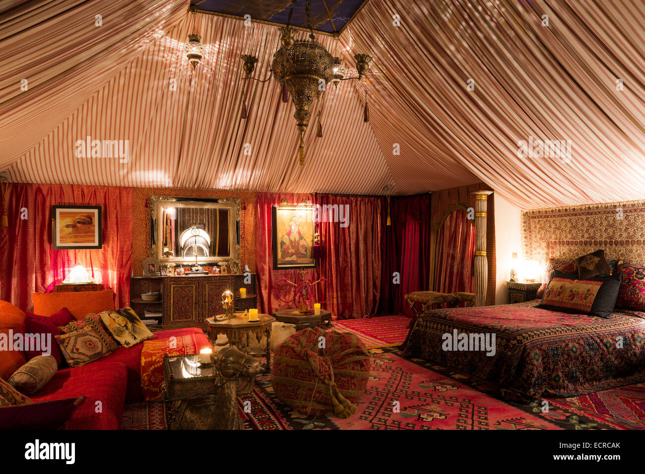 Chambre avec boudoir de style tente tapis marocain, tissus orientaux et tables d'appoint hexagonale Banque D'Images