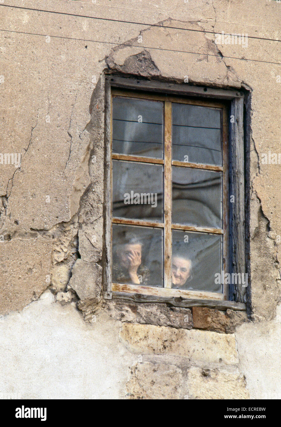 Deux femmes âgées vu à travers la fenêtre de sa maison en ruine, ce qui ...