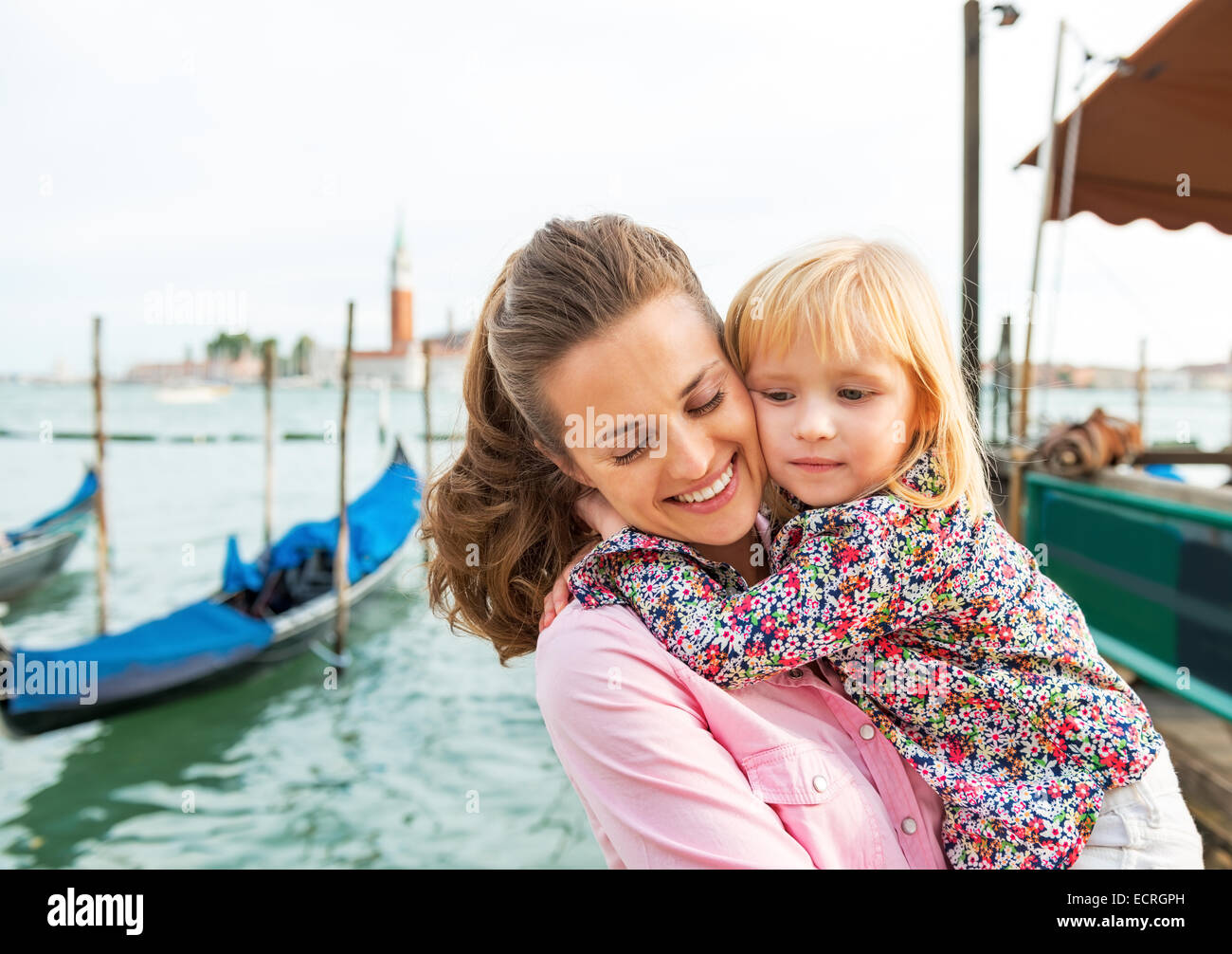 Portrait of happy mother and baby hugging sur grand canal embankment à Venise, Italie Banque D'Images