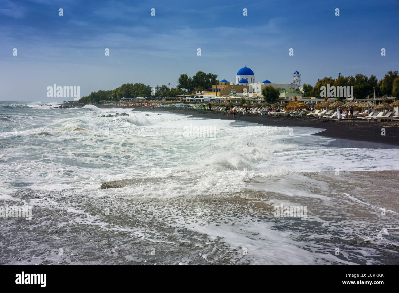 Mer agitée, plage avec chaises longues et coupole bleue de l'église grecque orthodoxe Banque D'Images