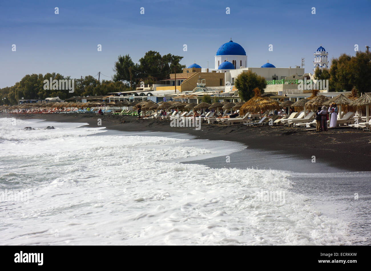 Mer agitée, plage avec chaises longues et coupole bleue de l'église grecque orthodoxe Banque D'Images