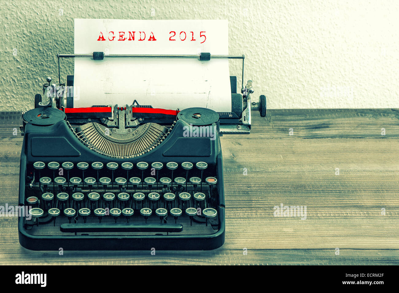 Machine à écrire avec du papier blanc sur la page table en bois. L'exemple de texte AGENDA 2015 style vintage photo aux tons. Banque D'Images