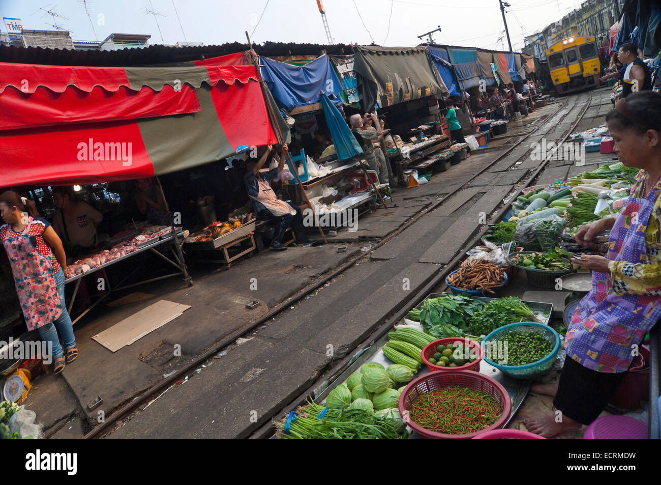 Vue horizontale d'un train approchant le marché à Maeklong. Banque D'Images