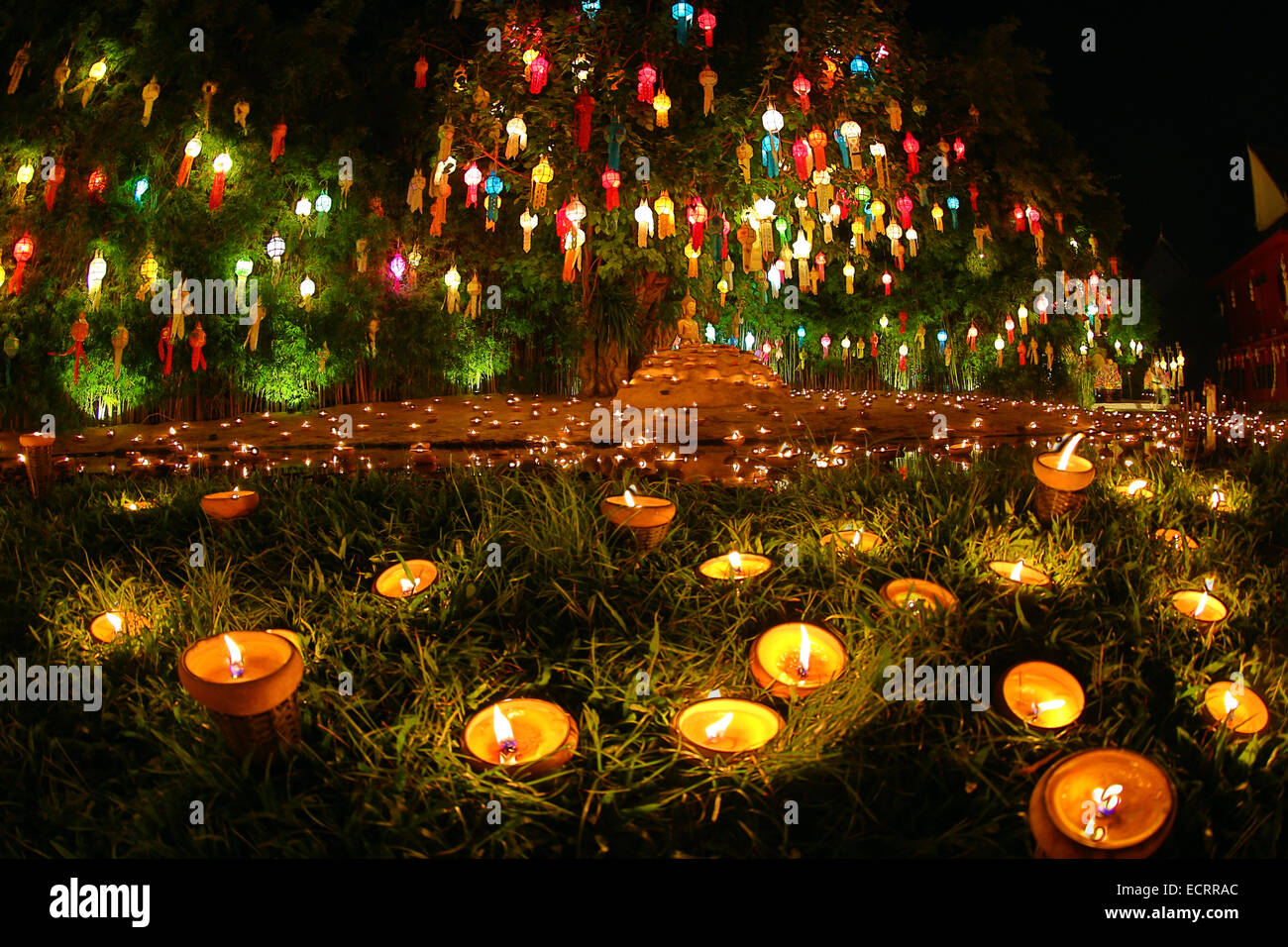 Lanternes et chandelles reflète dans une piscine avec une stature de Bouddha pour le Loy Krathong Festival at Wat Phan Tao temple à Chiang Ma Banque D'Images