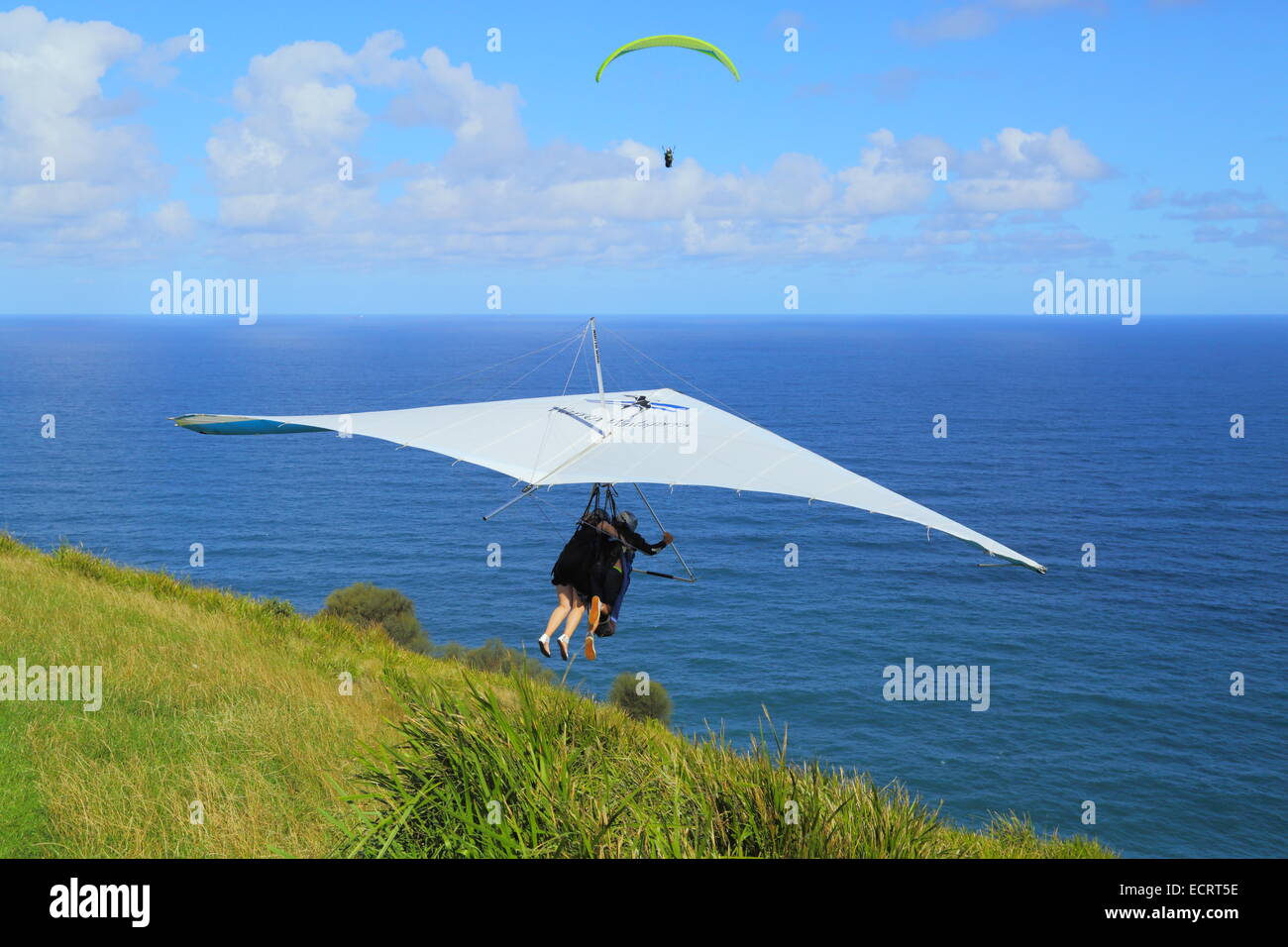 Un biplace parapente lance off Bald Hill, New South Wales, en Australie comme un parapentiste monte au-dessus de l'océan Pacifique. Banque D'Images