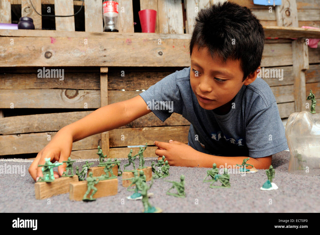 Mexique Cancun boy playing with toy soldiers dans des taudis Banque D'Images