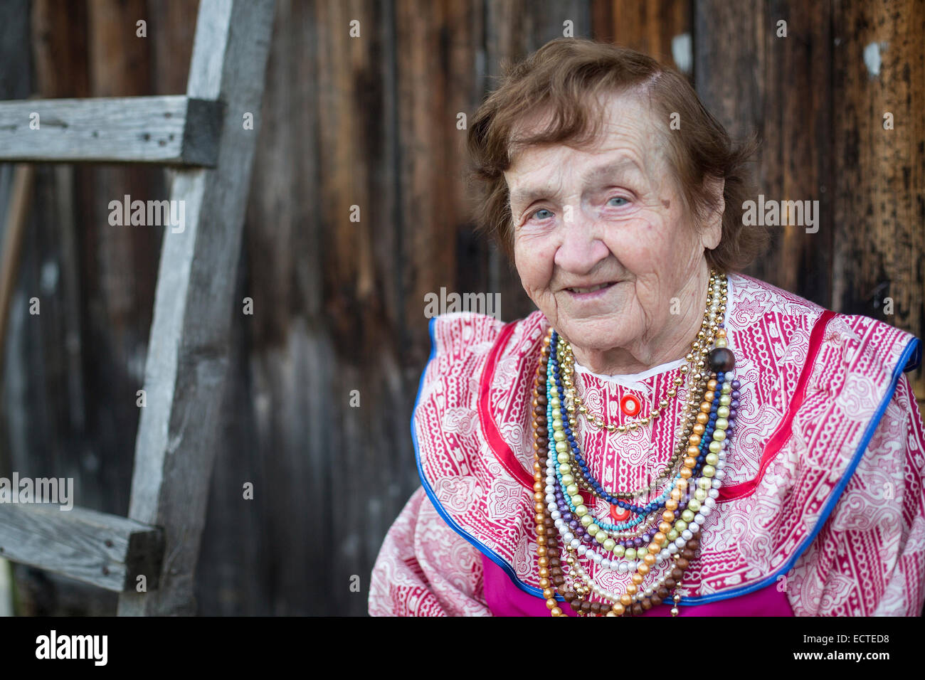 Portrait d'une vieille femme dans un brillant vêtements nationaux à l'extérieur dans la campagne. Banque D'Images