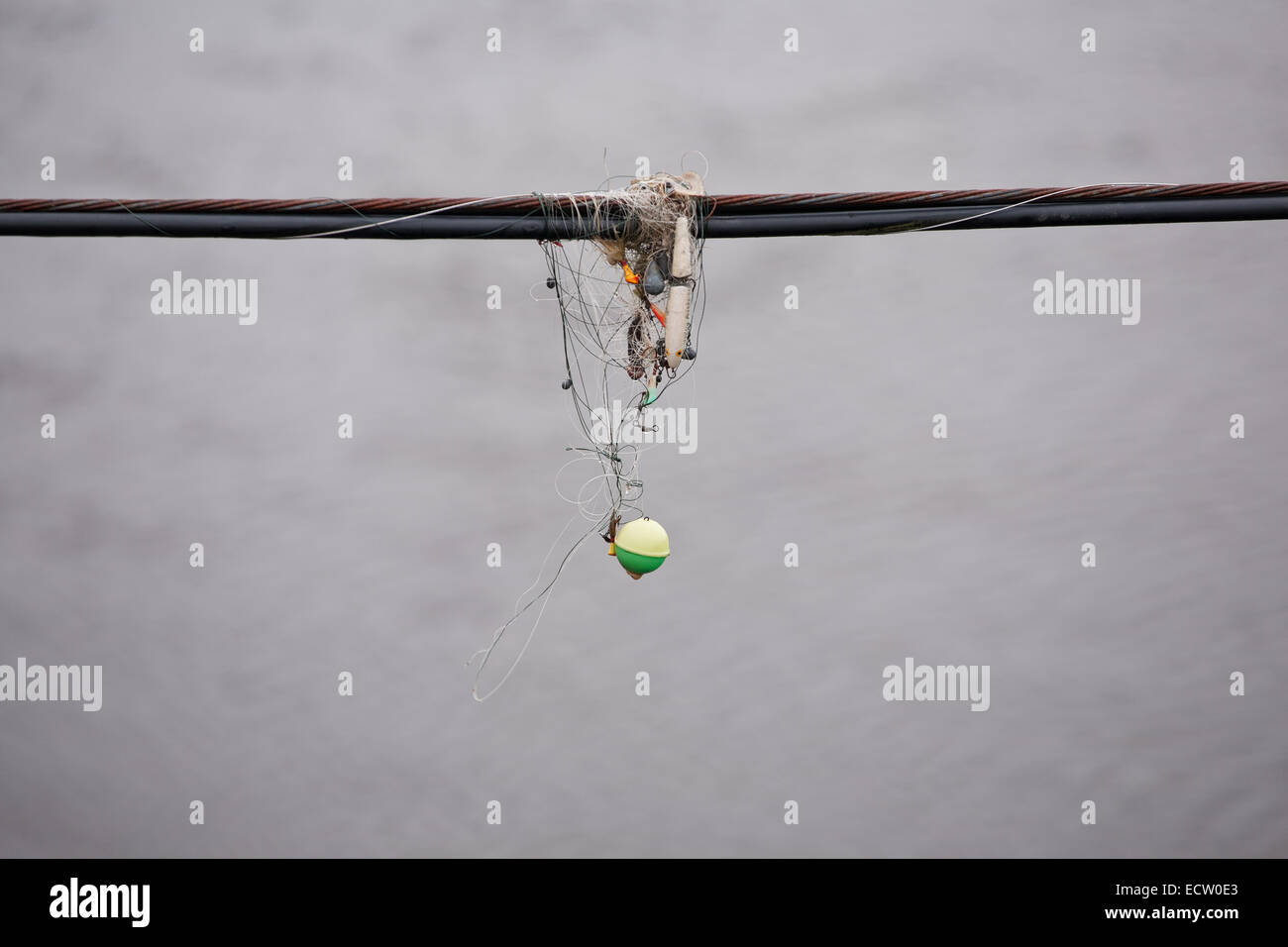 Divers matériel de pêche emmêlé sur le câble avec de l'eau ridée bokeh en arrière-plan. Banque D'Images