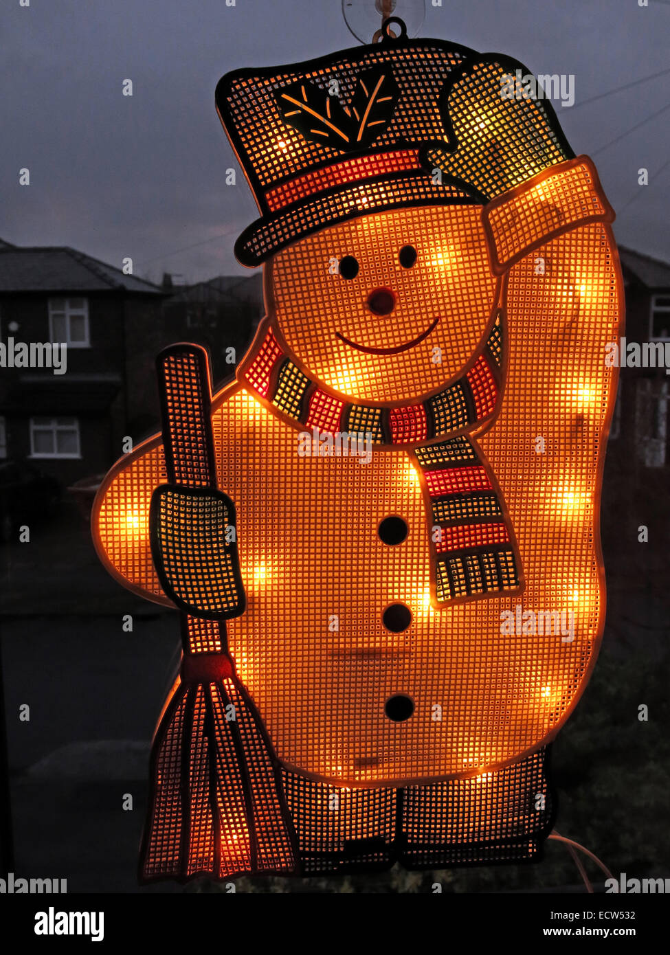 Un bonhomme de neige électrique sur une fenêtre, illuminé pour Noël Banque D'Images