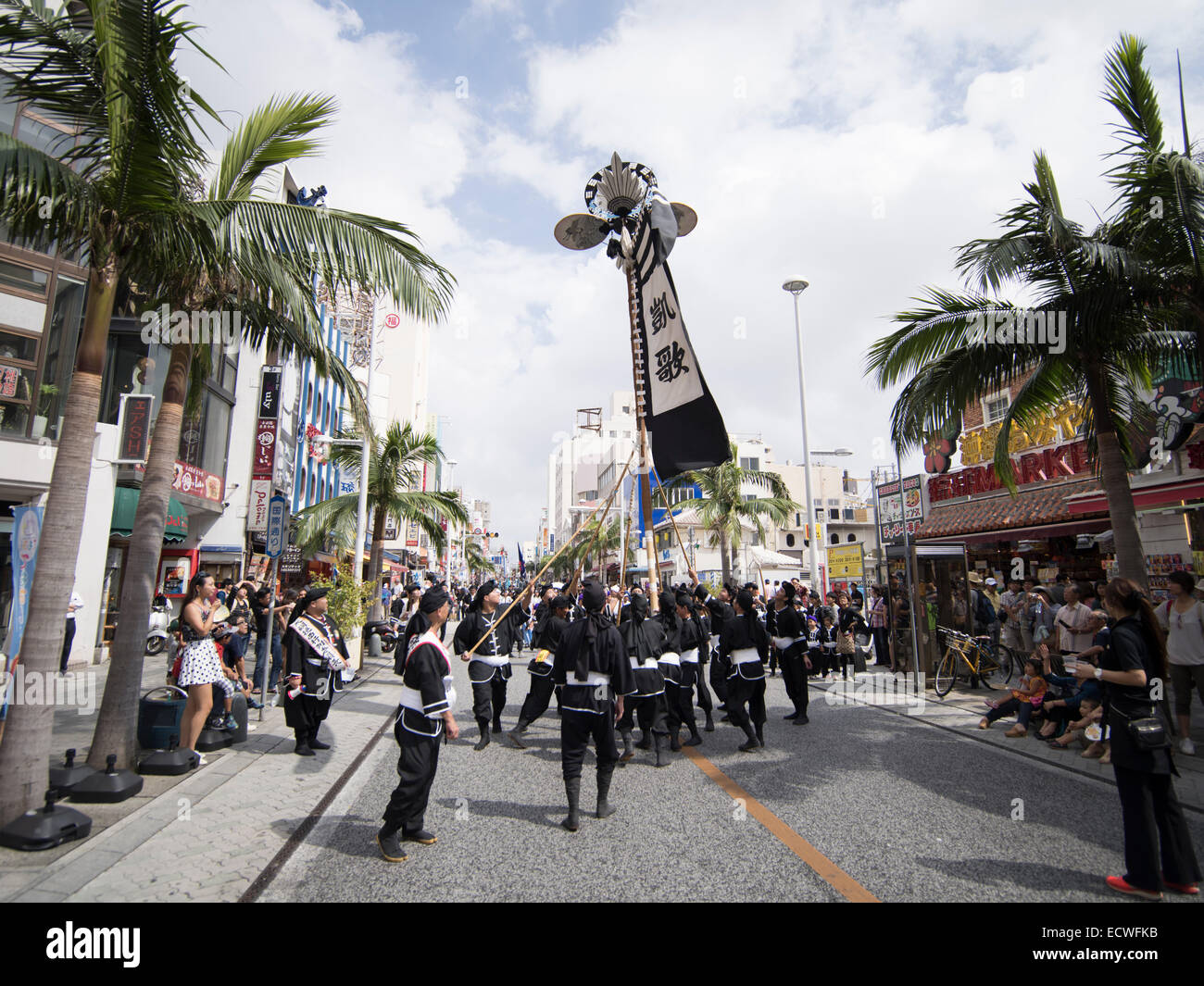 La bannière ( hatagashira / flag ) défiler devant le plus gros remorqueur de la guerre, Kokusai Street, la ville de Naha, Okinawa, Japon Banque D'Images