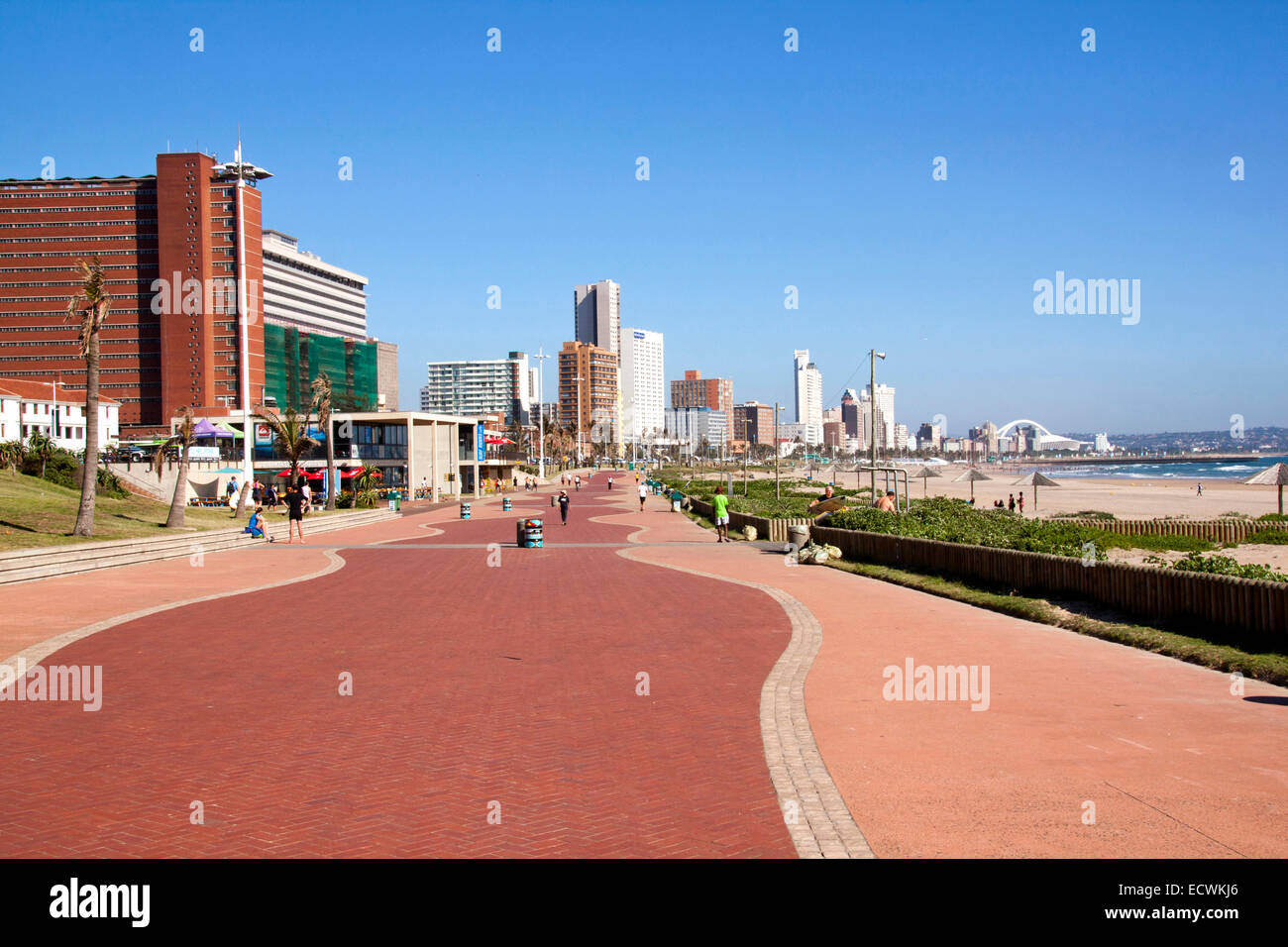 Inconnus à pied sur la promenade le long de la plage d'Addington contre 'Golden Mile' sur les toits de la ville de Durban, Afrique du Sud Banque D'Images