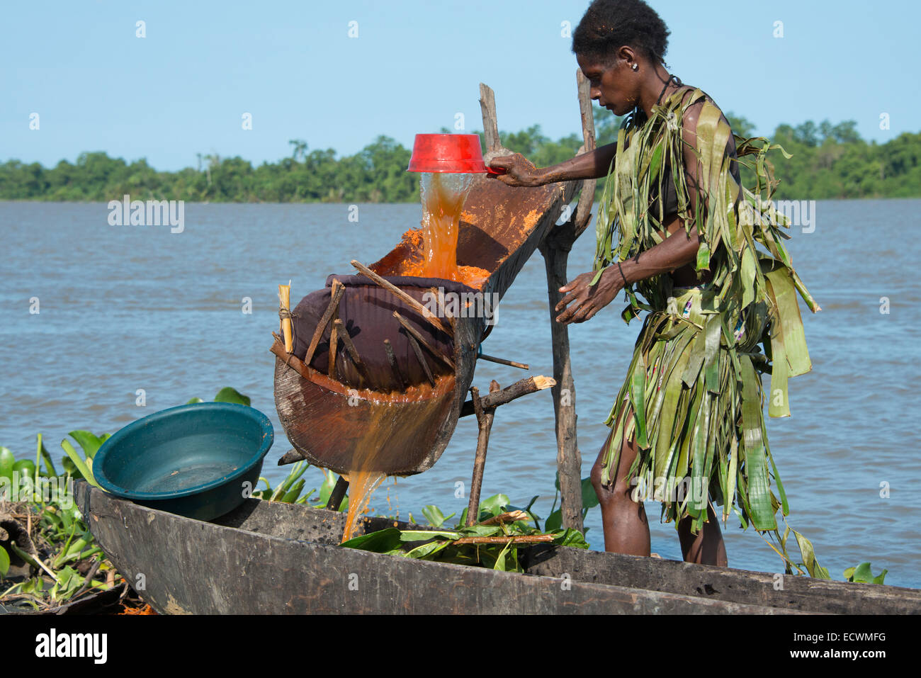 En Mélanésie, la Papouasie-Nouvelle-Guinée, fleuve Sepik, village de Kopar. Femme en tenue de feuille de palmier le long de la rivière. Banque D'Images