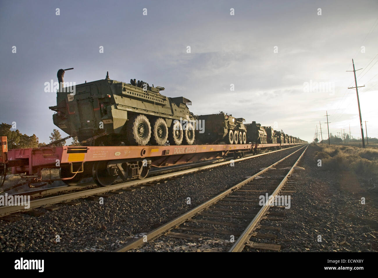 Le personnel de l'armée des transporteurs et des autres véhicules de l'armée de terre à bord d'un train de fret en direction sud à travers le centre de l'Oregon. Banque D'Images