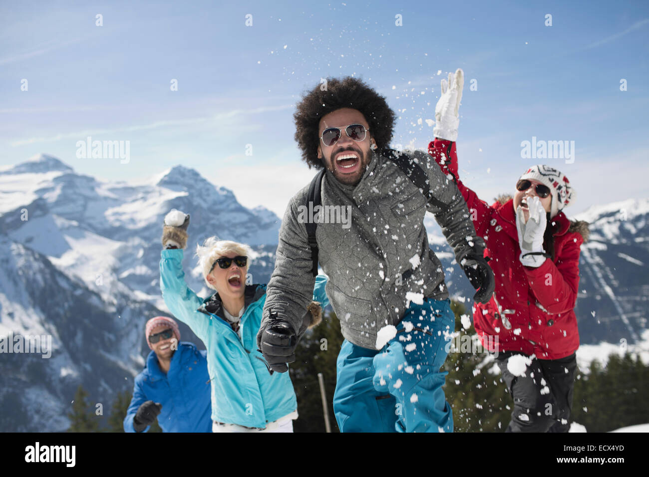 Friends enjoying snowball fight à mountain Banque D'Images