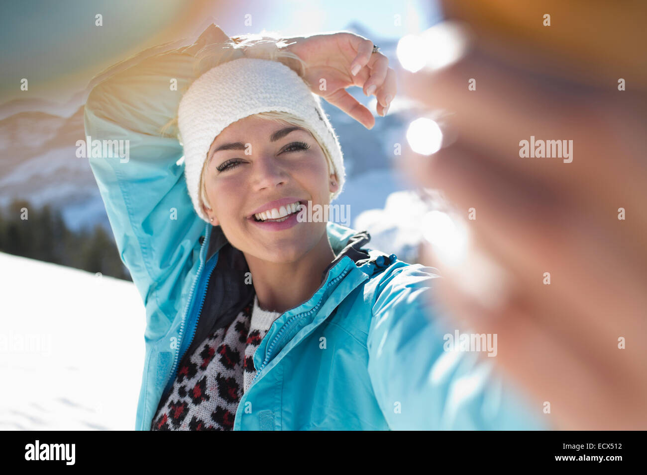 Femme heureuse en tenant dans la neige selfies Banque D'Images