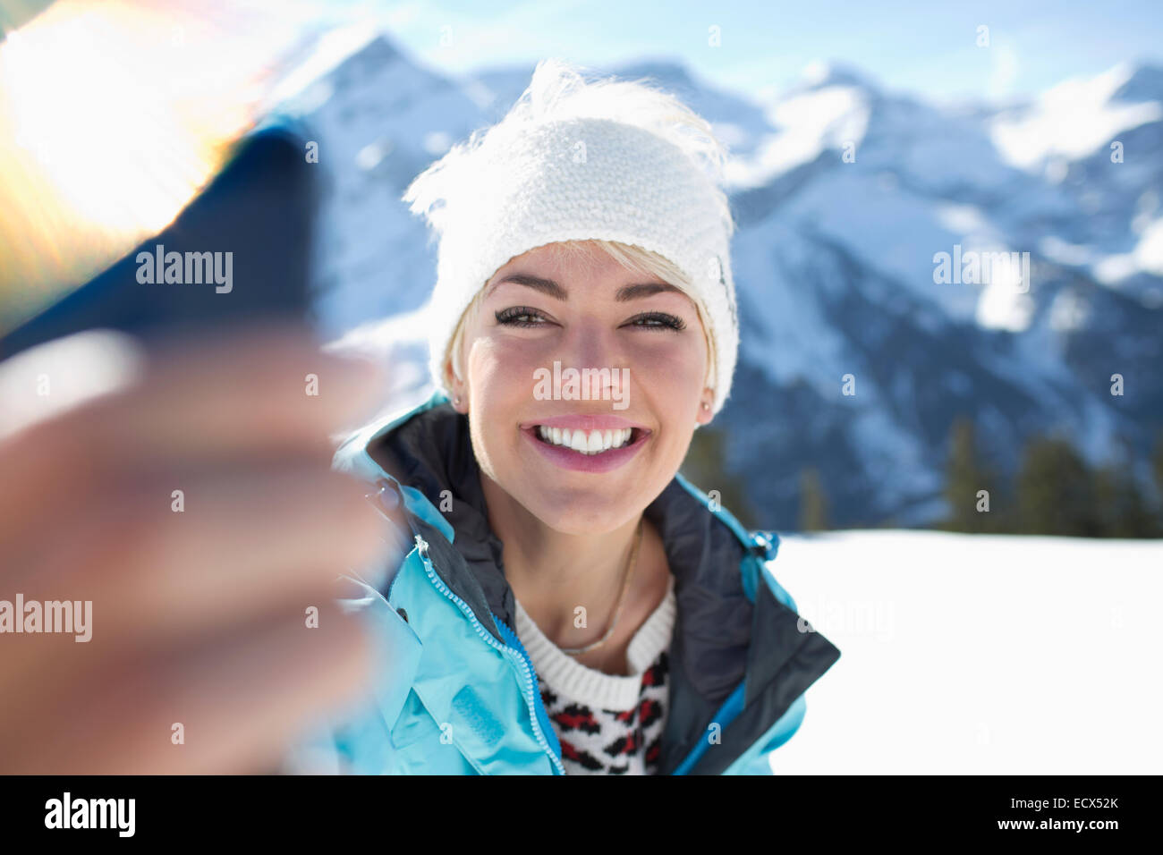 Femme souriante en tenant dans la neige selfies Banque D'Images