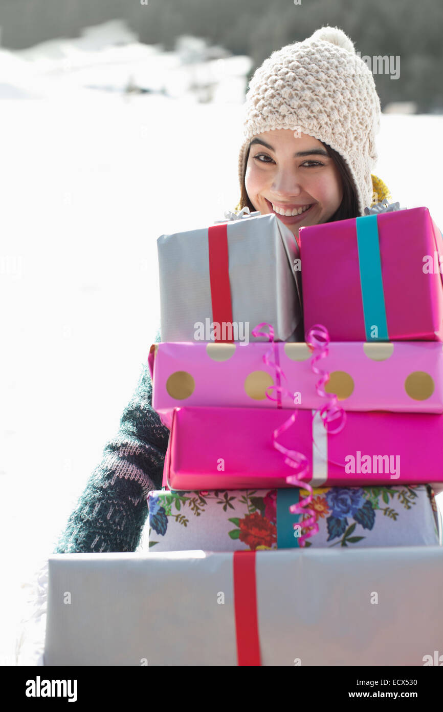 Portrait of smiling woman carrying pile de cadeaux Banque D'Images