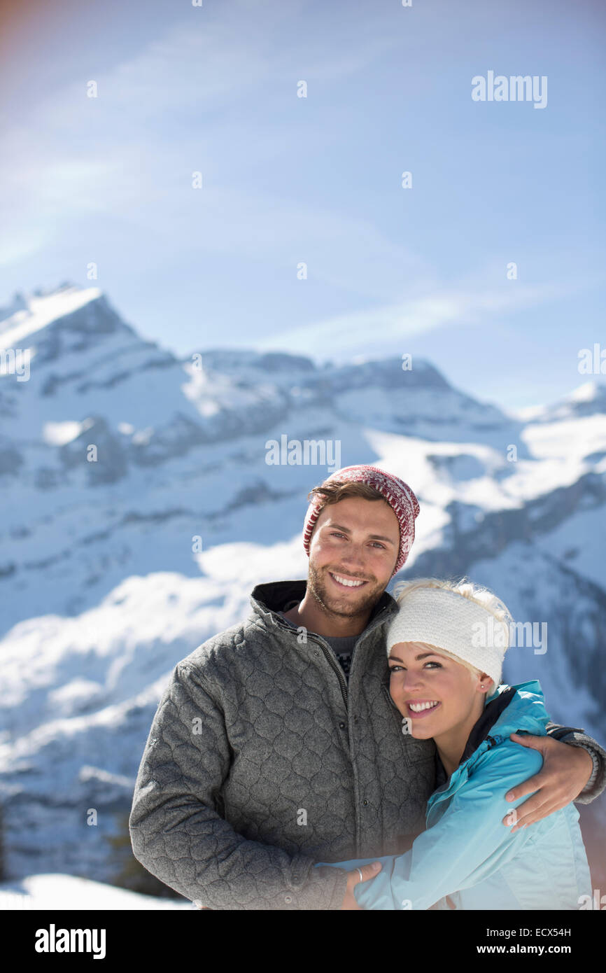 Portrait of smiling couple hugging ci-dessous mountain Banque D'Images