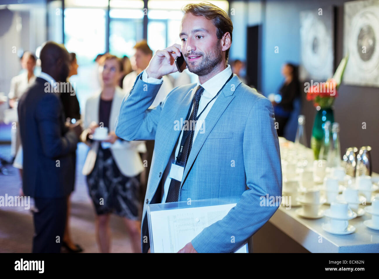 Businessman standing in office document et à l'aide de mobile phone Banque D'Images