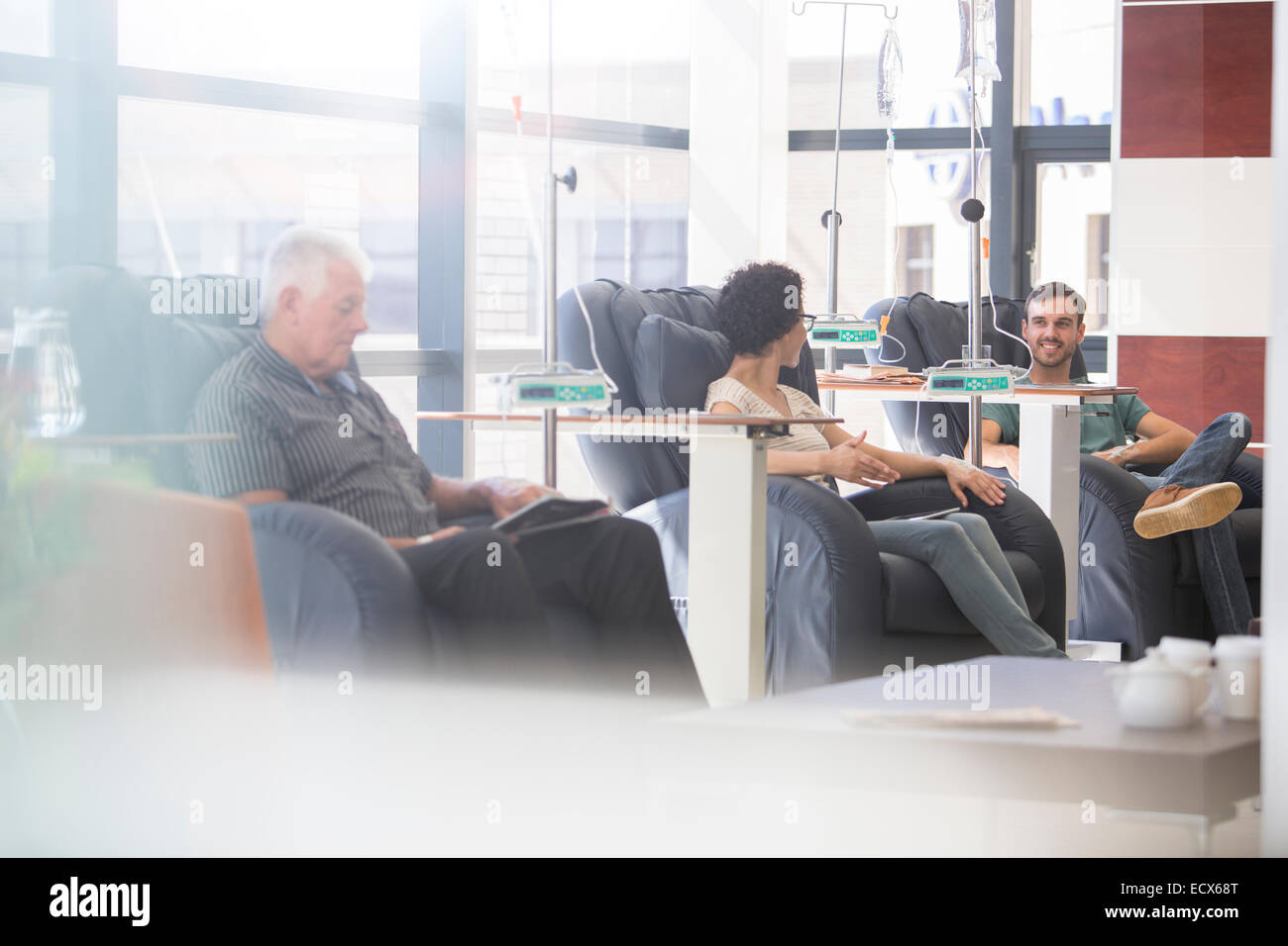 Les patients sous traitement médical dans les fauteuils in hospital ward Banque D'Images