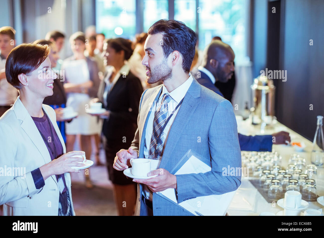 Portrait de l'homme et de la femme qui parle dans le hall du centre de conférence au cours de pause café Banque D'Images