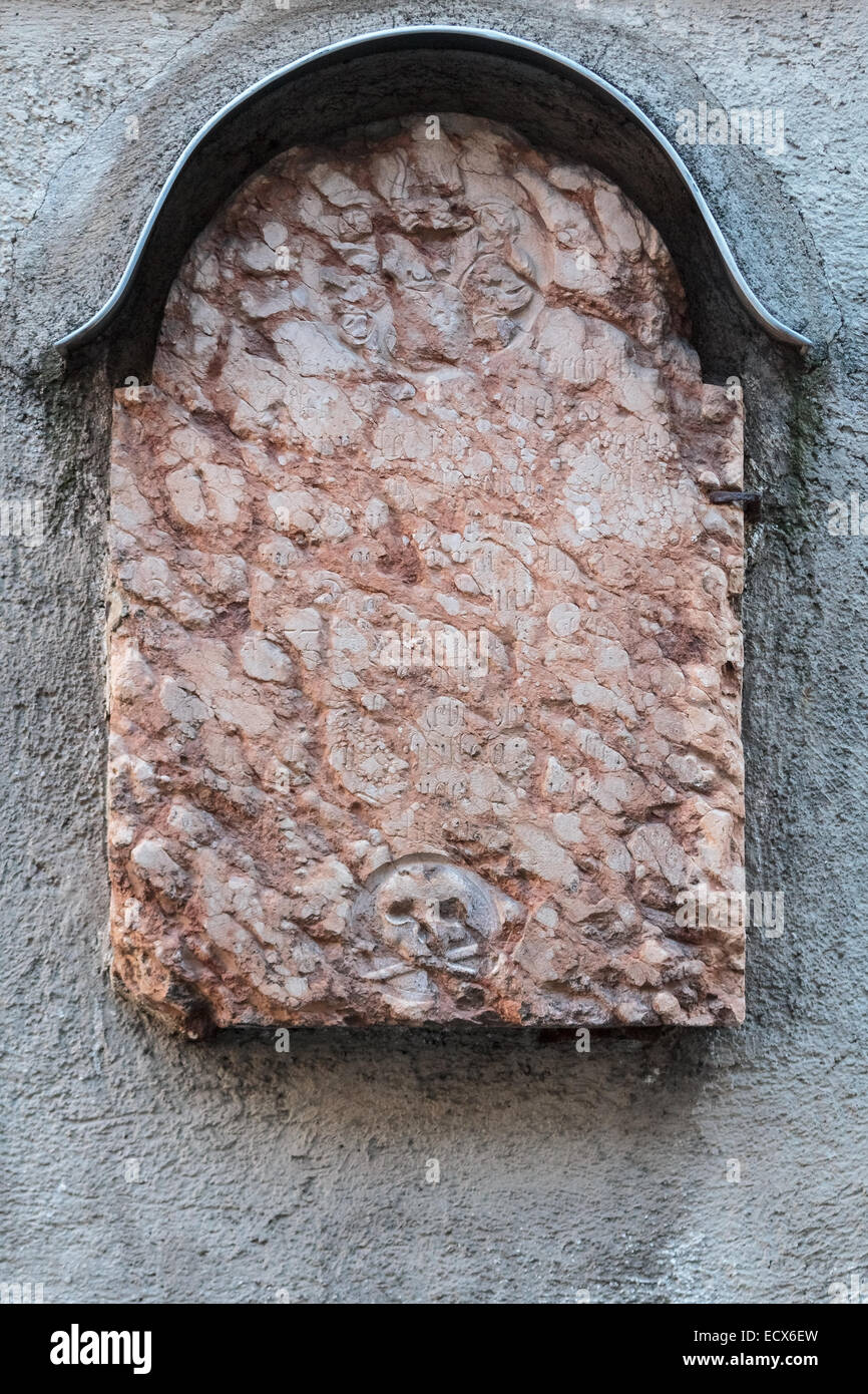 Une case vide et rugueux tombstone rouge sur un mur d'une église à Munich, en Allemagne, avec un crâne Banque D'Images