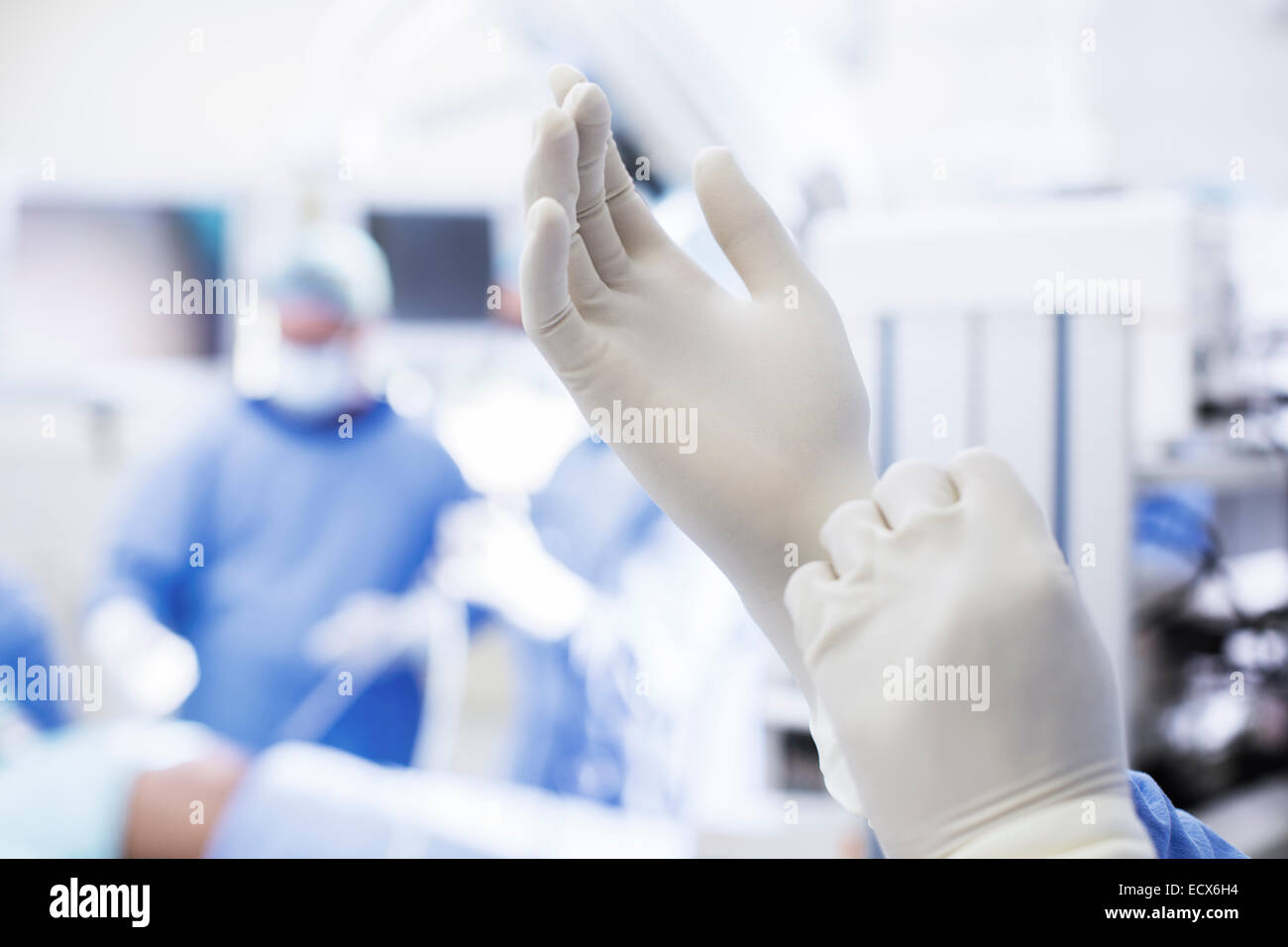 Close-up de chirurgien de mettre des gants chirurgicaux en salle d'opération Banque D'Images