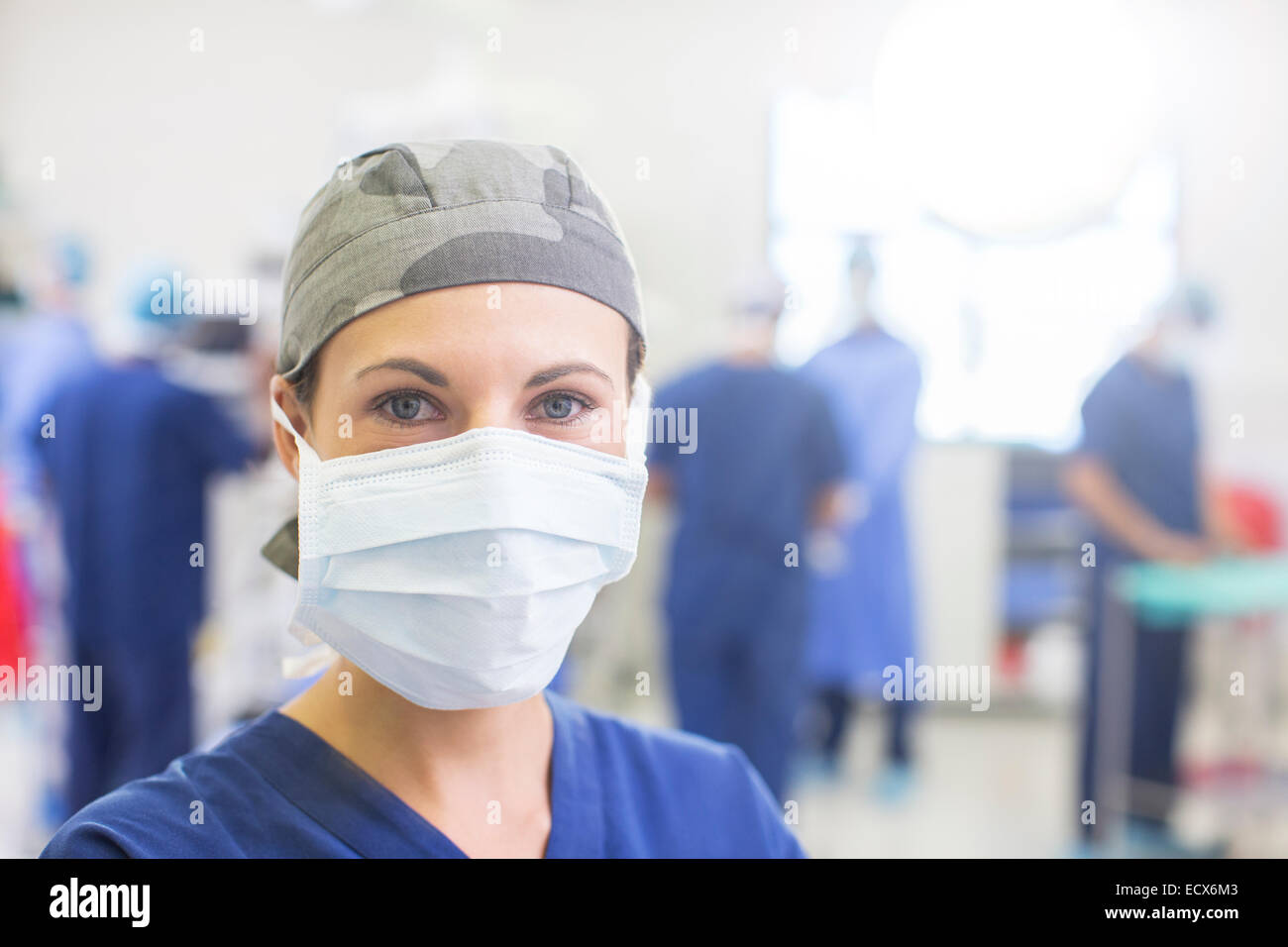 Portrait of female doctor wearing surgical cap et le masque dans le théâtre d'exploitation Banque D'Images
