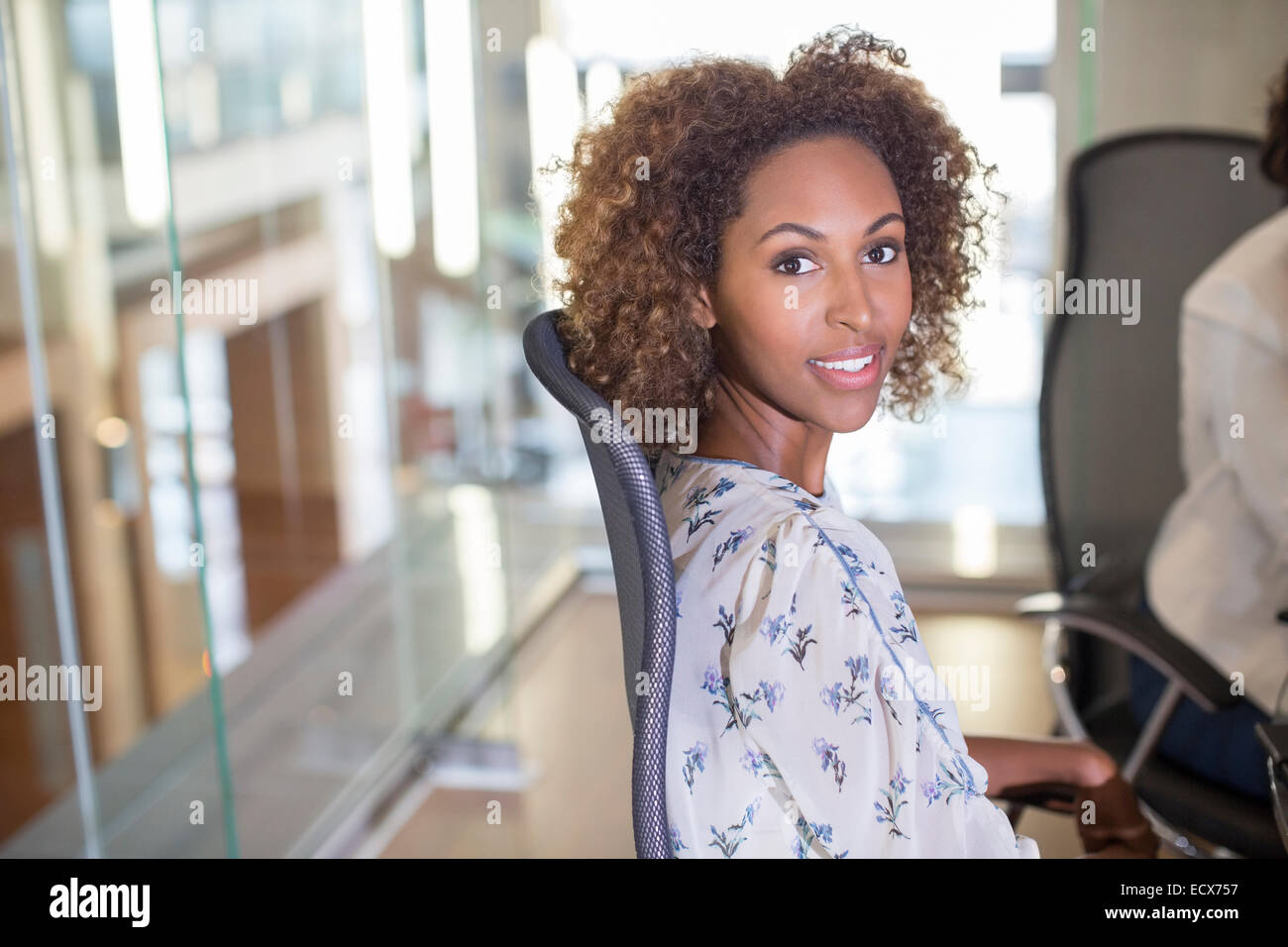 Portrait of young businesswoman sitting in chair et looking at camera Banque D'Images