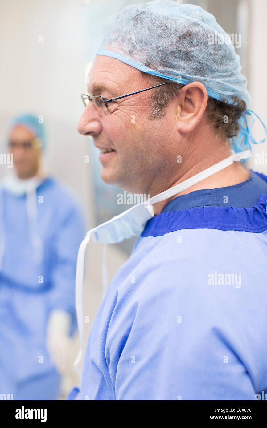 Vue latérale du surgeon wearing glasses, blue surgical cap and gown Banque D'Images