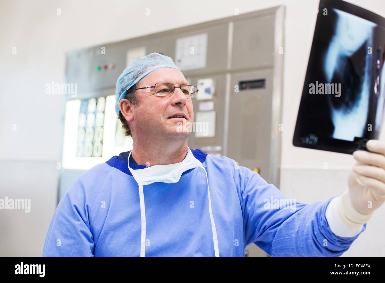 Woman surgical cap and gown looking at x-ray en salle d'opération Banque D'Images