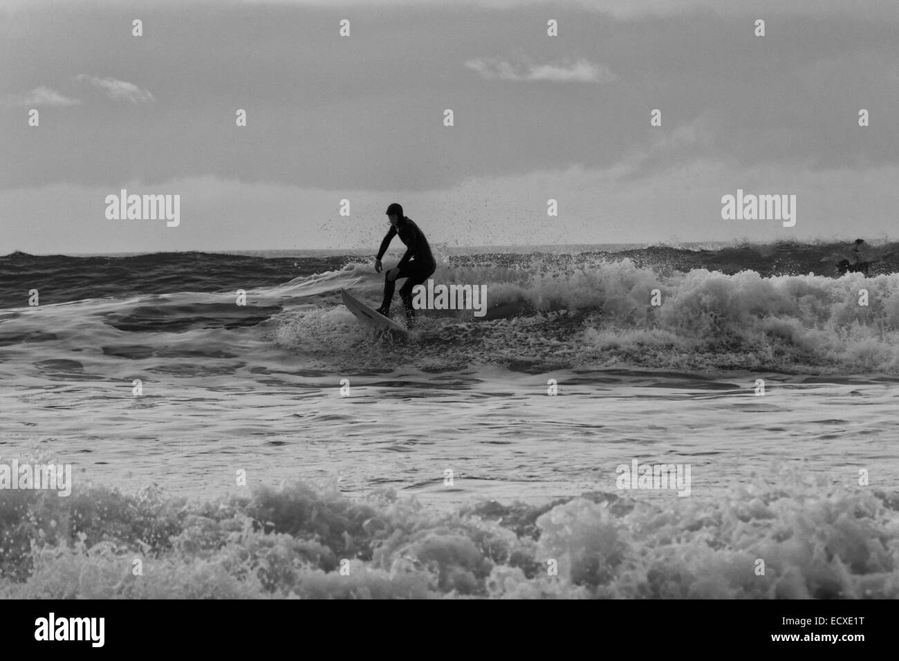 De bonnes conditions en mer permet à un internaute de rouler une bonne vague pour une longue course au nord du Pays de Galles, Porth Neigwl Banque D'Images