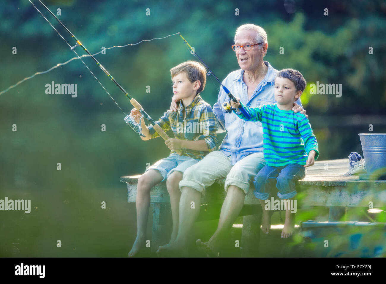 Grand-père et ses petits-fils la pêche dans le lac Banque D'Images