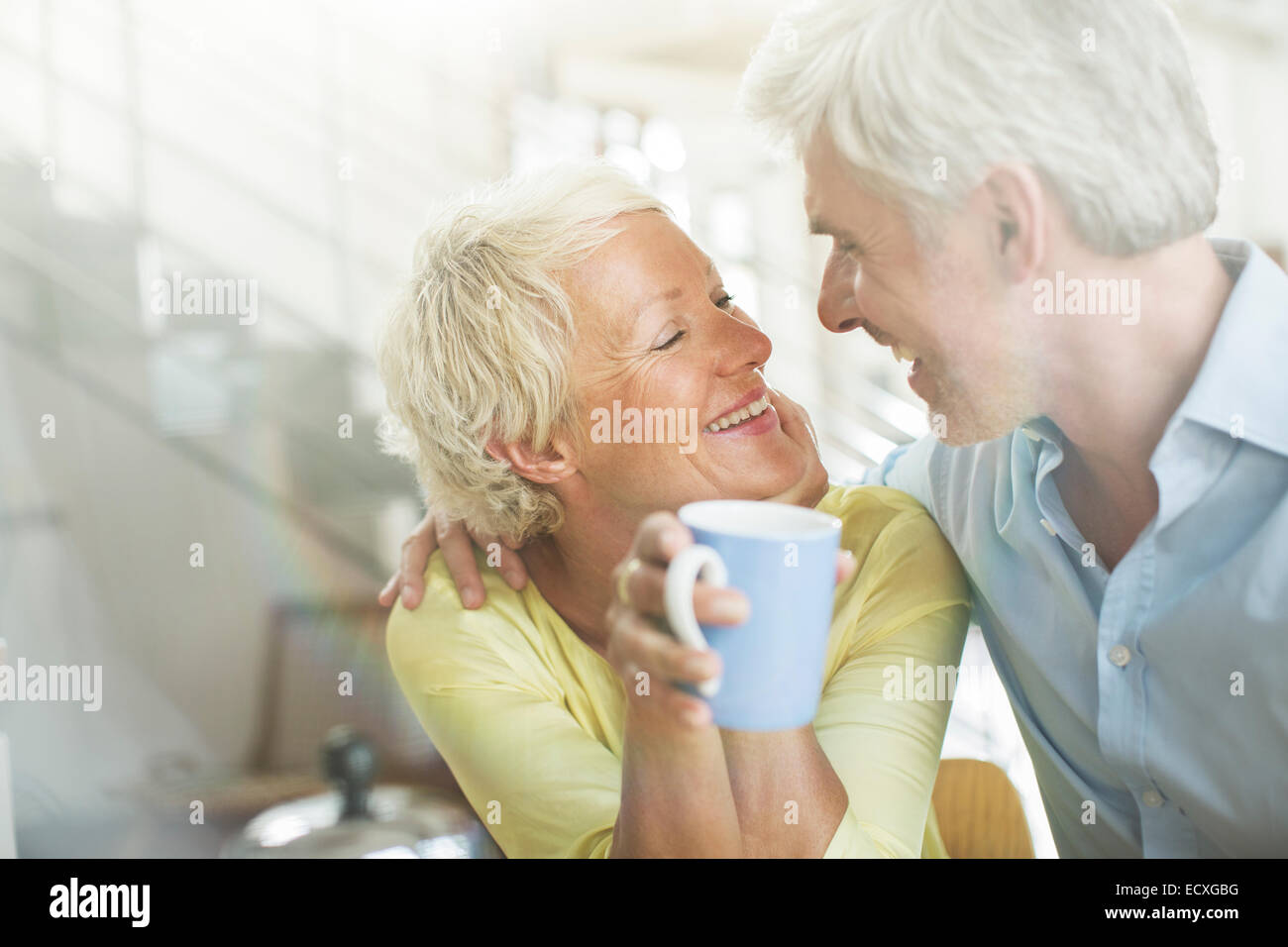 Vieux couple hugging with coffee cup Banque D'Images