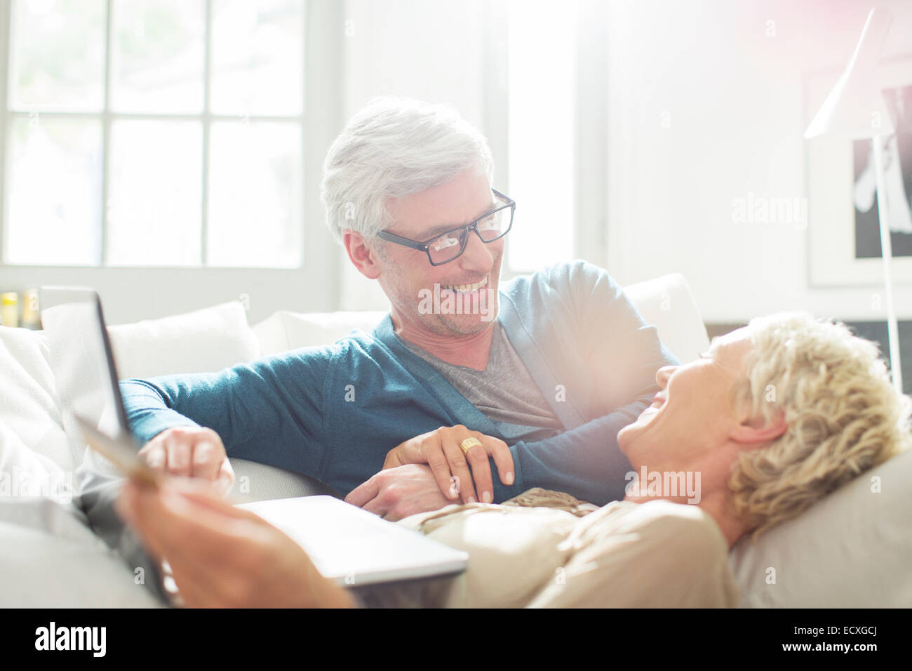 Vieux couple relaxing together on sofa Banque D'Images