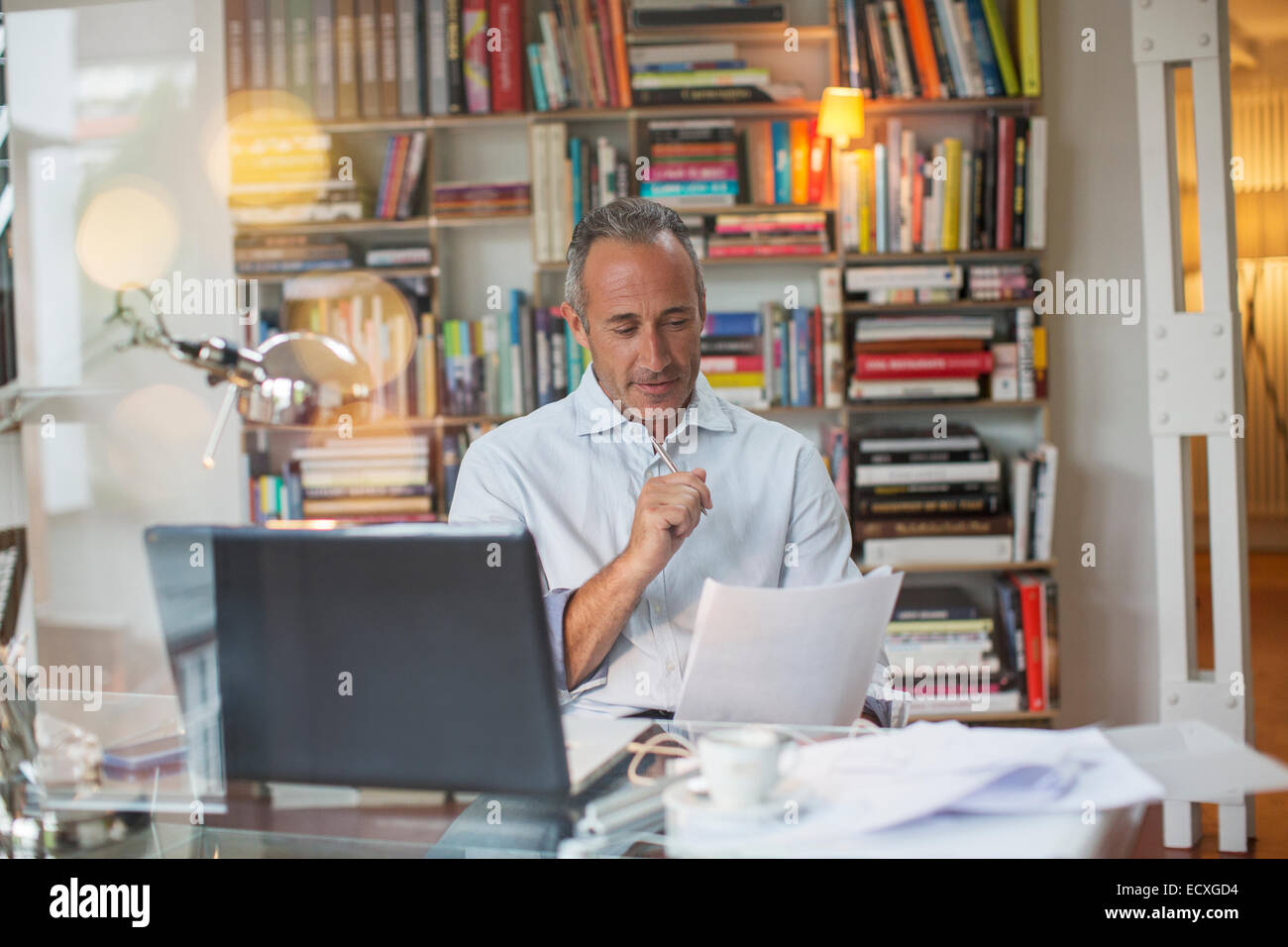 Businessman reading paperwork at home office 24 Banque D'Images