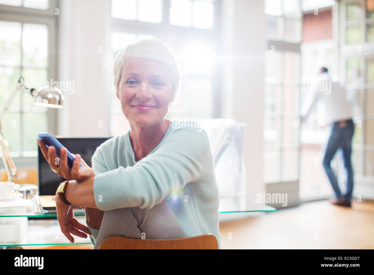 Businesswoman using cell phone at home office 24 Banque D'Images