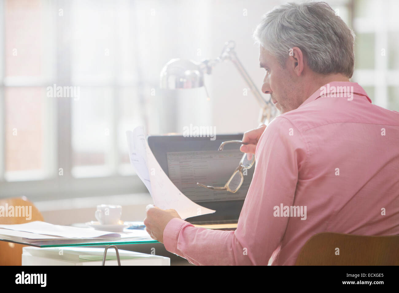 Businessman reading paperwork at home office 24 Banque D'Images