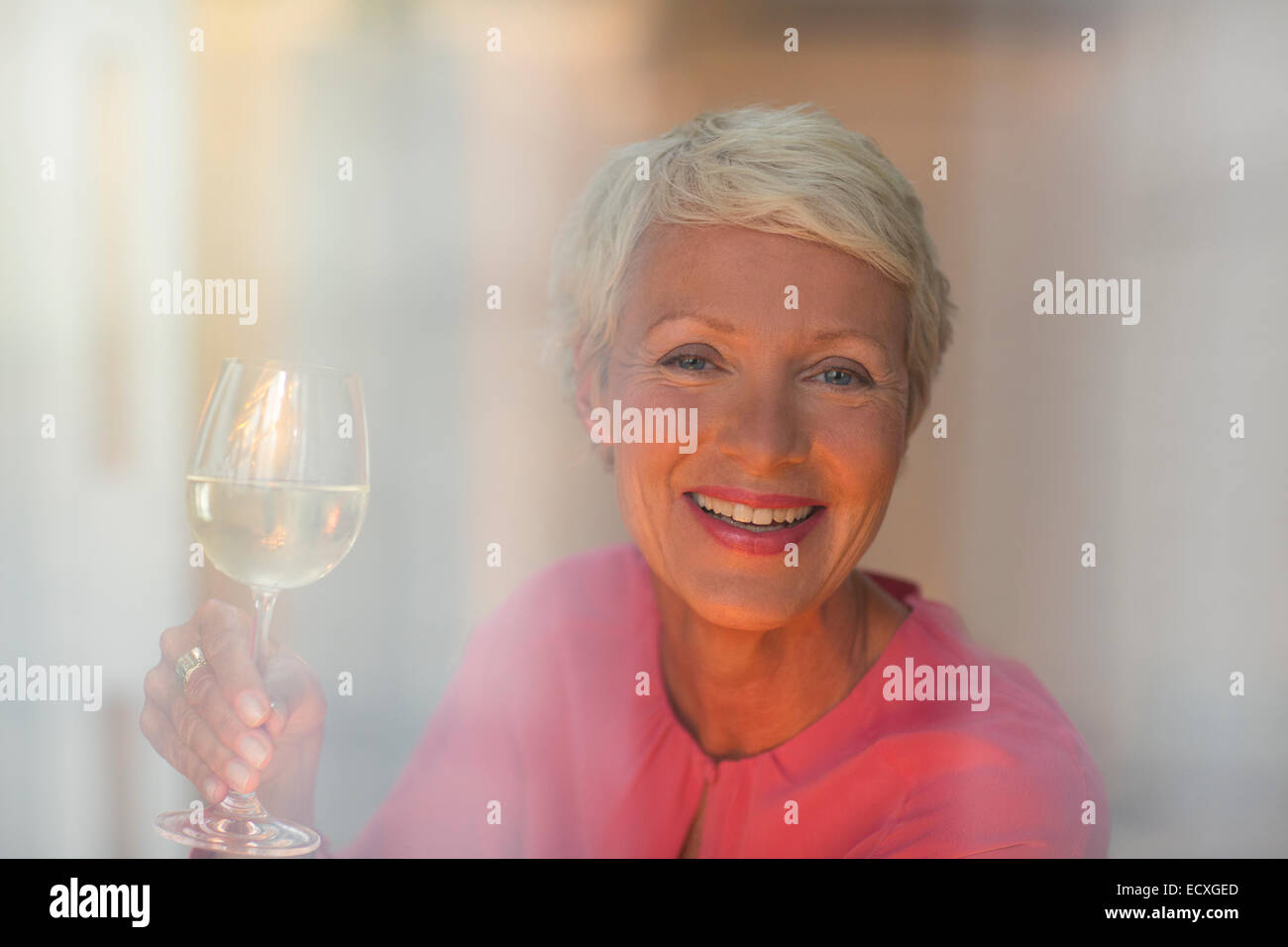 Femme Plus de boire dans un verre de vin blanc Banque D'Images