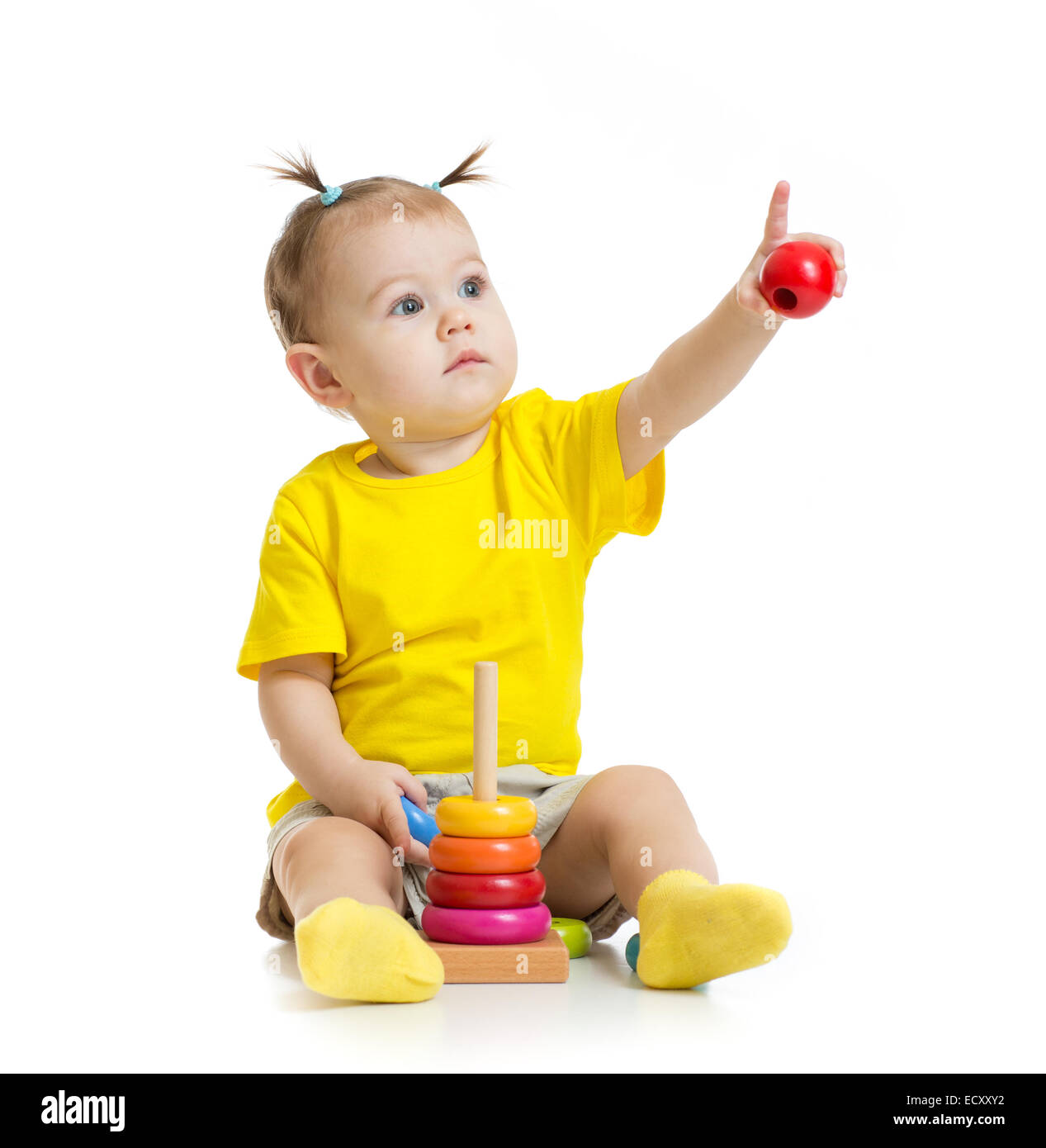 Bébé jouant avec des jouets colorés et en pointant du doigt par isolé Banque D'Images