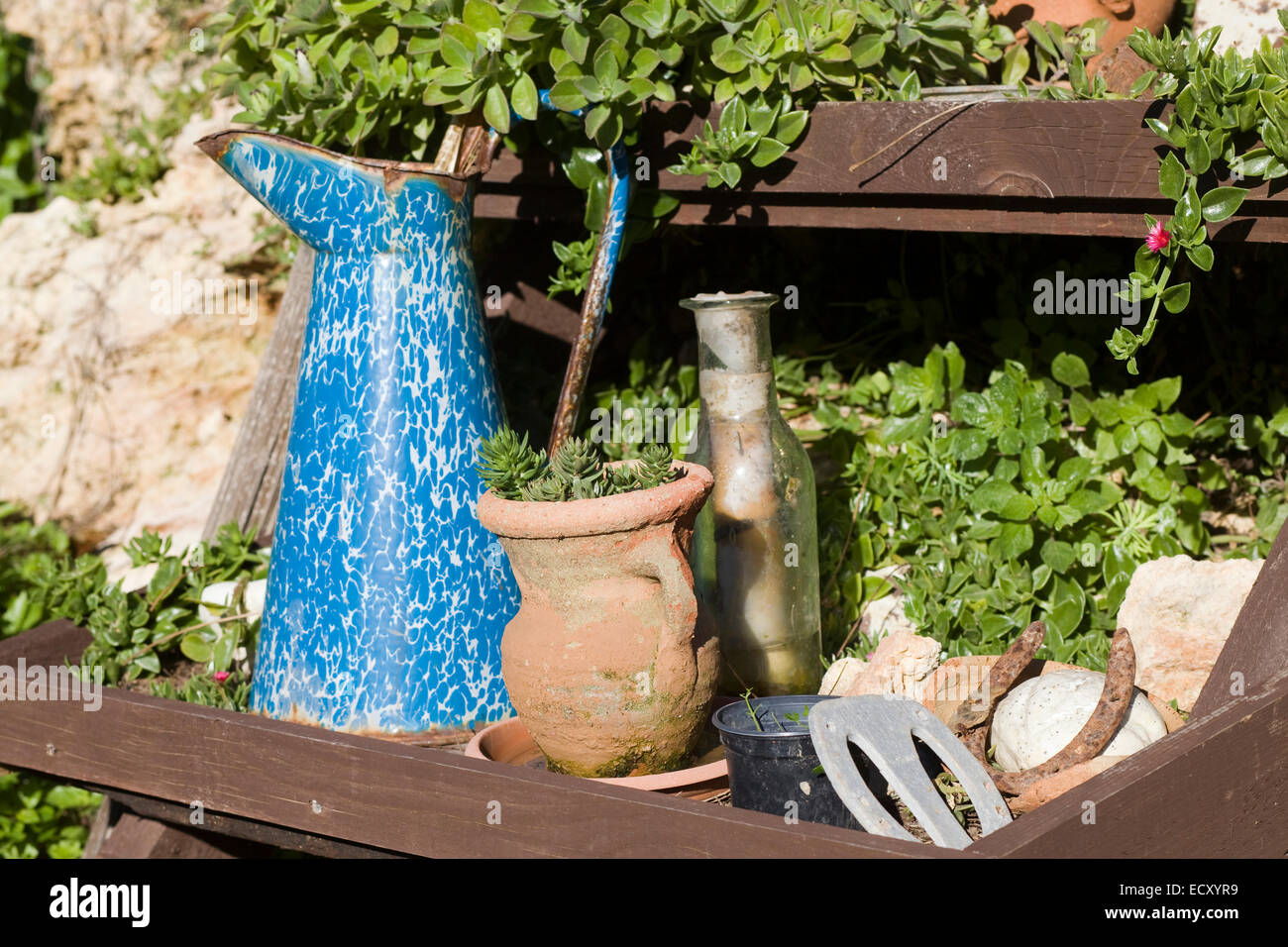 Ancienne verseuse en métal et terre cuite dans un pot de fleurs en bois Banque D'Images