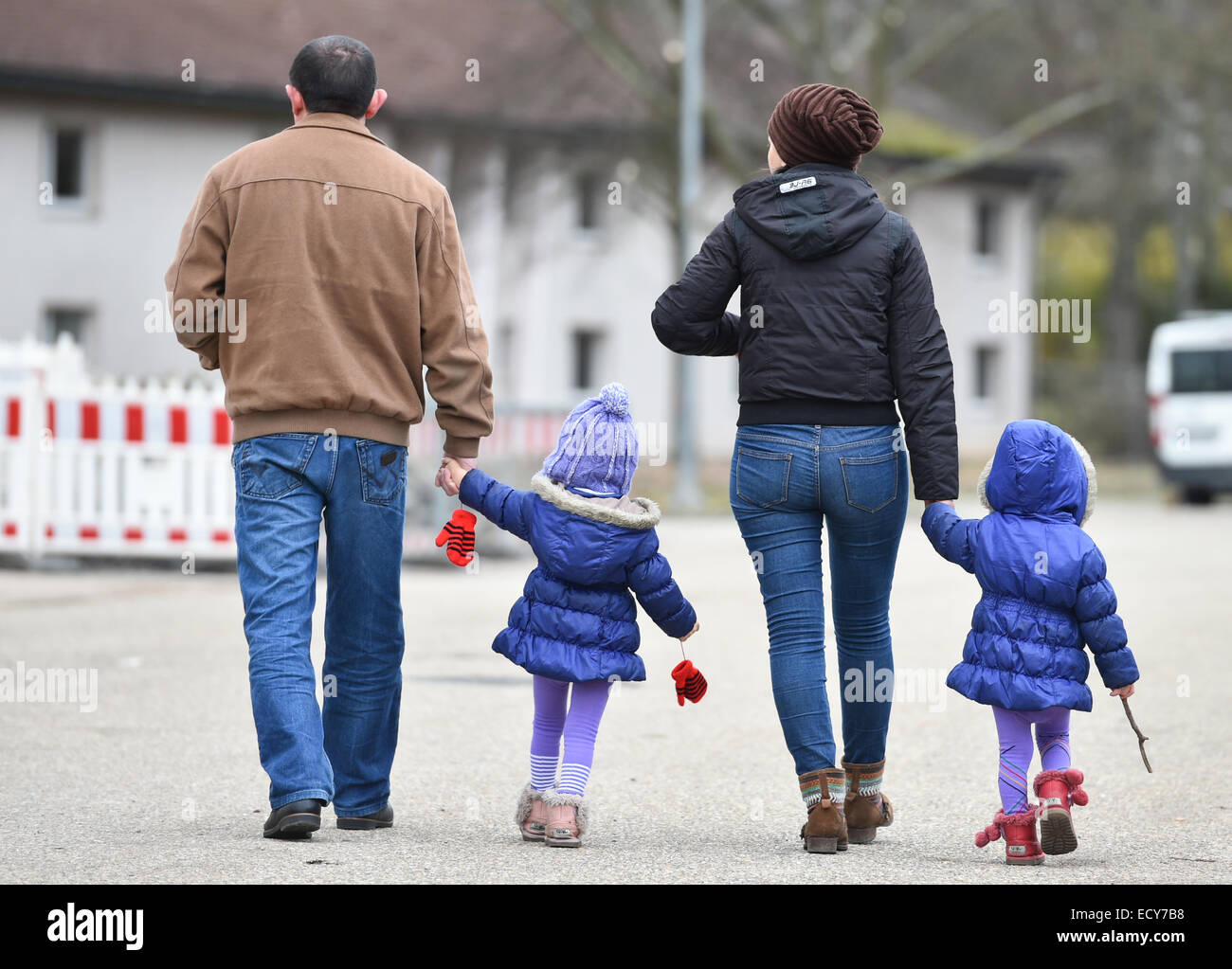 Heidelberg, Allemagne. Dec 22, 2014. Une famille de réfugiés traverse une rue à un abri d'urgence pour des motifs de Patrick Henry Village (PHV) à Heidelberg, Allemagne, 22 décembre 2014. L'ancienne installation de l'armée américaine, une fois à la maison pour quelques 16 000 soldats américains et leurs familles, est transformé en un refuge pour les réfugiés plus qu'un an après les grands logements sont a finalement fermé ses portes en septembre 2013. PHOTO : UWE ANSPACH/dpa/Alamy Live News Banque D'Images