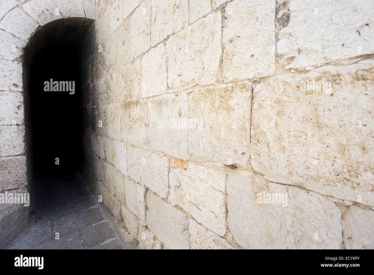 Dark passage avec un mur de pierre Banque D'Images